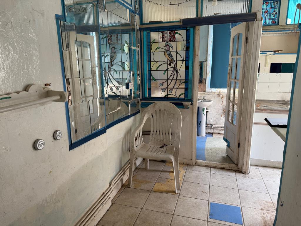 Lot: 146 - PATIO FLAT IN NEED OF REFURBISHMENT - Kitchen area with door to bathroom